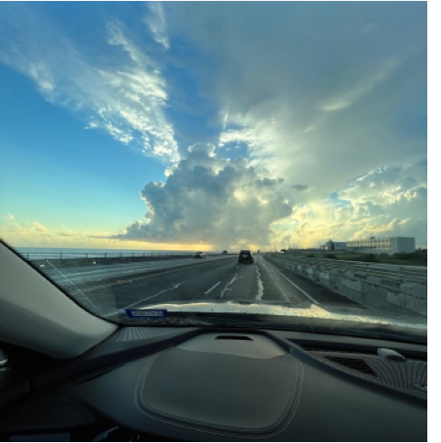 A view of a road from inside of a car
	
	Description automatically generated